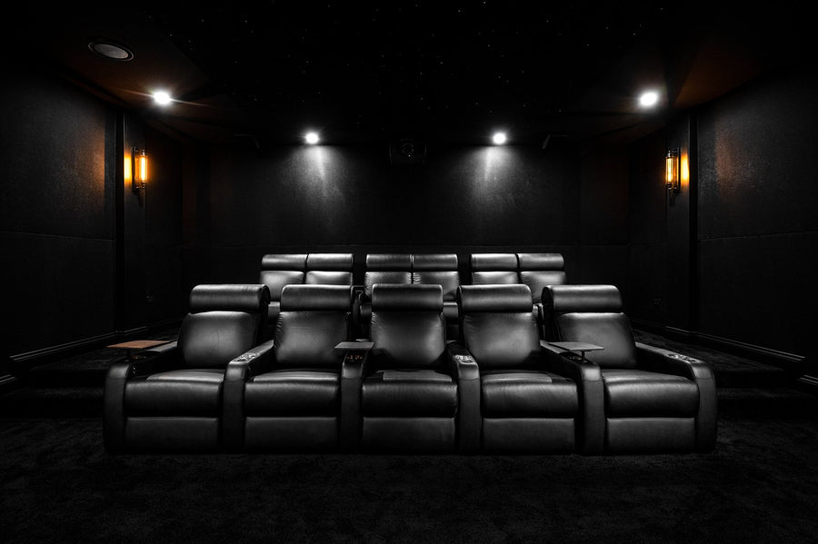 Two tiered rows of black leather recliners in the cinema.